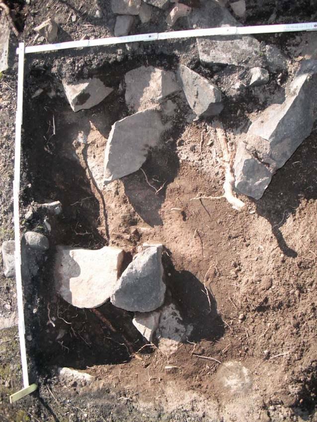 Två meterrutor (R1 och R2) upptogs i den skadade delen av gravens
