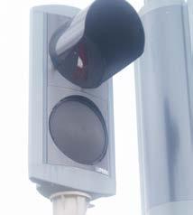 Signal med täckt grön ljusöppning i gångsignal som reglerar fotgängare över spårväg i gatumitt.