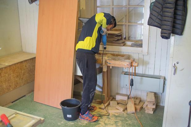 Sommarjobbare borrar hål i träbitar för bostäder till solitärbin. Eggeby gård 2015.