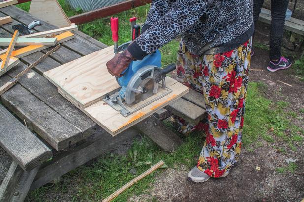 Sommarjobbare kapar plywood skivor till en topplistkupa. Eggeby gård 2015.