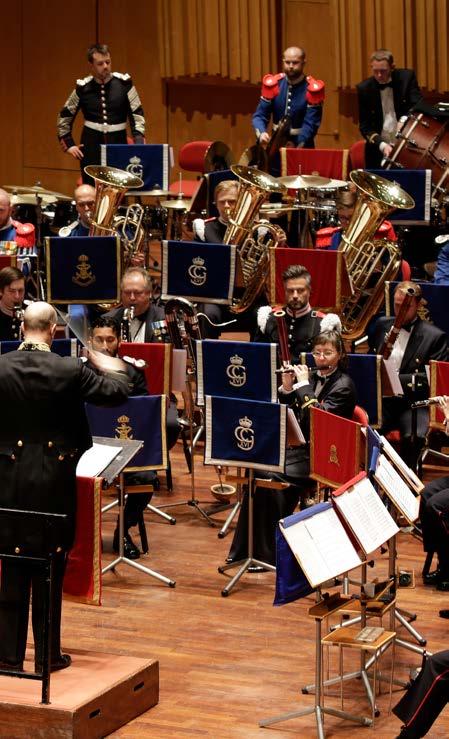 På Berwaldhallens scen bildar närmare 100 musiker från Försvarsmusikens tre musikkårer, Arméns Musikkår, Livgardets Dragonmusikkår och Marinens Musikkår, en stor symfonisk blåsorkester.