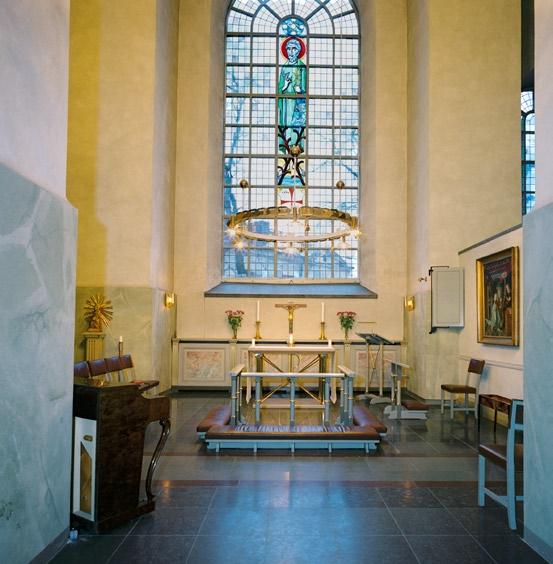 Altarringen av trä är marmorerad likt altaret med förgylld dekor. Dopkapellet har ett altare av grå kalksten, med en inskription på fronten. På väggen bakom finns en draperimålning.