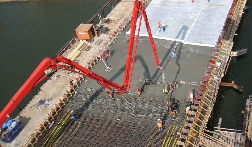 Roterbilar transporterar betongen flytande till arbetsplatsen som antingen pumpas upp med hjälp av speciella betongpumpar, se figur 34, eller lyfts upp i betongbaskar på bron.