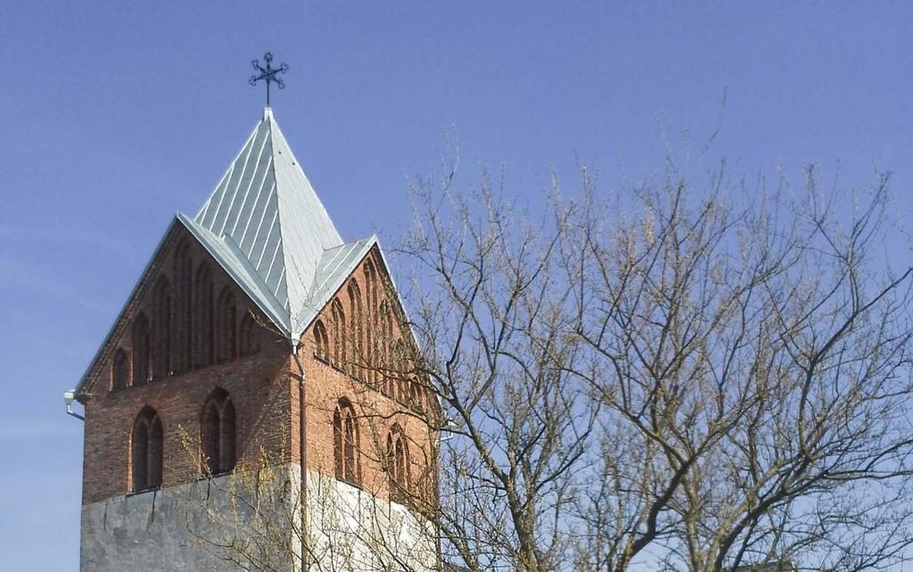 Figur 3. Odarslövs kyrka med torn i väst. Kyrkogården är fortfarande i bruk. Fotografiet taget från sydväst.