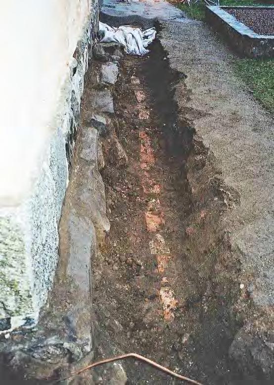 I princip berördes redan omgrävda lager. Det berodde på gravgrävningar men också på kabelgrävningar. Figur 5. Schaktet vid salkyrkans (korets) östra grundmur. Under tegelmarkeringen låg en kabel.