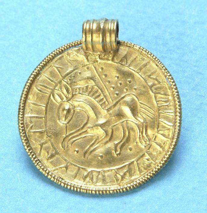 En runinskrift omger djurbilden och runt om motivet finns en bård och en ögla (Figur 9). 20 Väsbybrakteaten är identisk sånär som på bårdens utseende med en brakteat från Eskatorp i Västergötland.