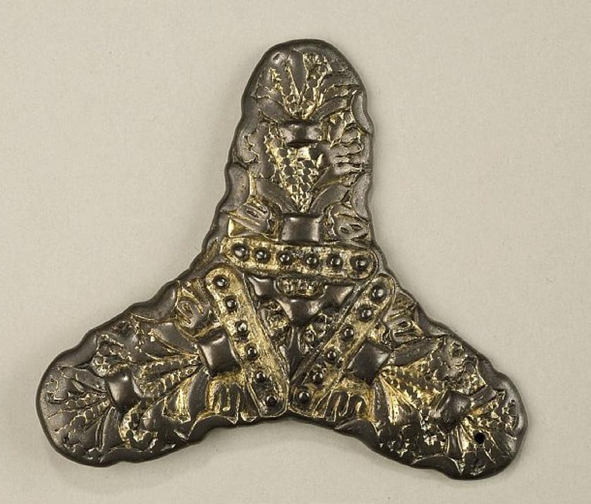Smycket är av brons och av mycket god kvalité och nästan inte alls slitet, även om det finns en senare skada (Figur 12). Spännbucklor var använda i par för att fästa kjolens hängslen i själva kjolen.