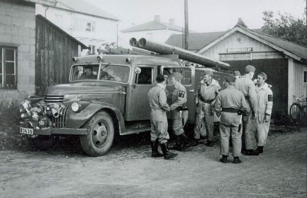 Finnerödja borgarbrandkår omkring 1960 utanför det provisoriska garaget. Till vänster om brandbilen syns Kalles bilverkstad. Trea från vänster står William Gustavsson. Lite statistik från 1959.