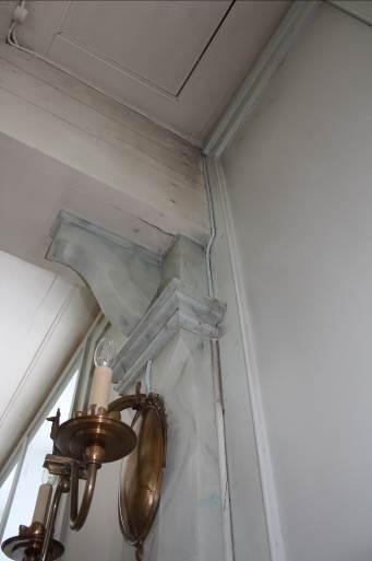 Här ses en av kabeldragningarna till lampetterna i långhuset och dess inmålning.
