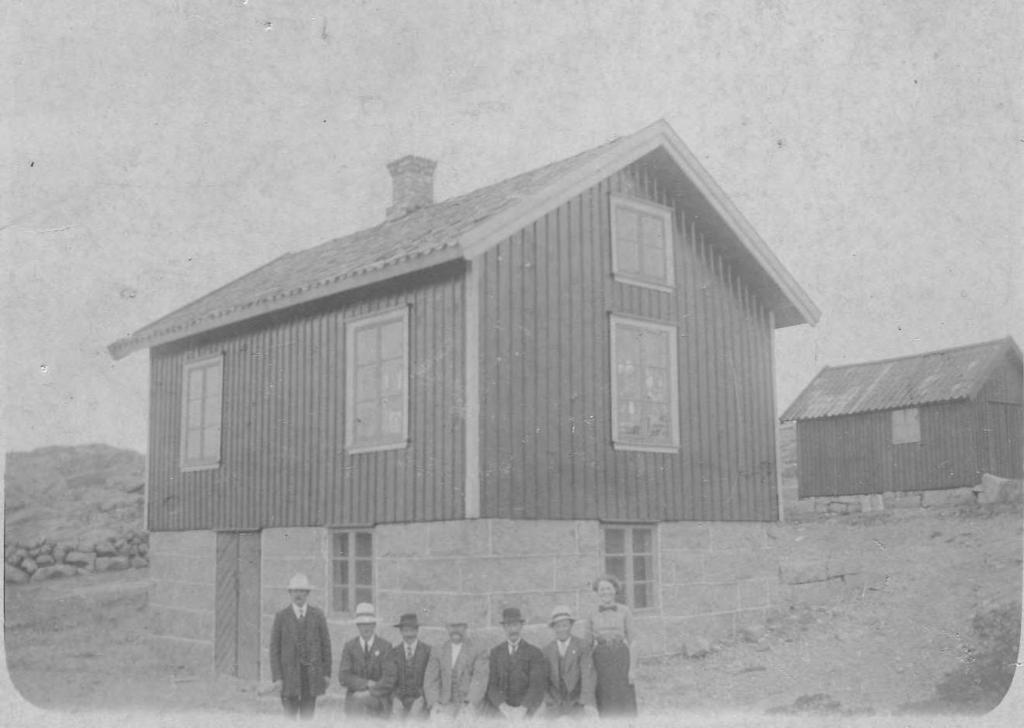 På denna bild från 1908-1909 poserar delar av styrelsen och revisorer samt biträdet framför föreningens hus.