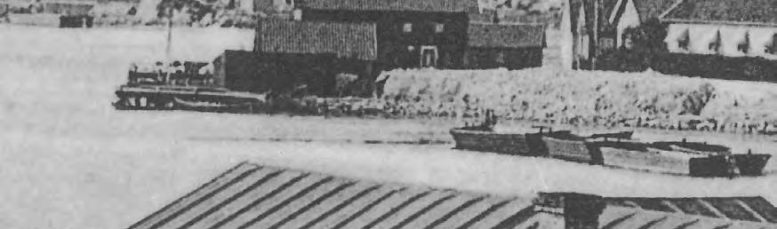 Gammalt foto på Lökeskär med pråmar, stenupplag och ett magasin i bakgrunden t.v. I förgrunden Uddens utskeppningsbrygga, som ägdes av C A Kullgren.