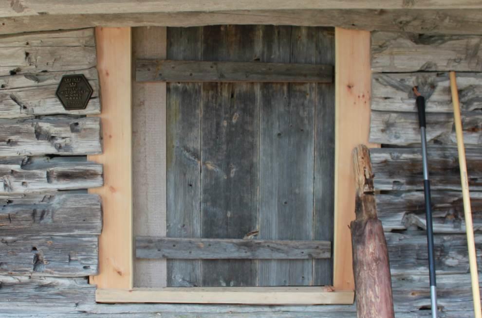 Dörr: Dörr saknades innan åtgärd. På äldre bilder går att utläsa att öppningen tidigare täcks av liggande brädor som fällts ned i spår på sidorna.