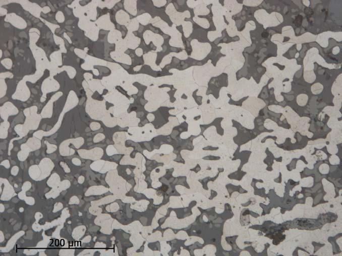 Figur 31. Fnr 922. Det svampiga järnet är ferritiskt (svagt brunfärgade fält) och omgivet av slagg. Etsat prov. Metallografisk analys Oregelbundet tvärsnitt med svampigt metalliskt järn.