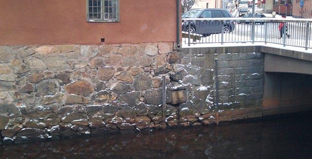 Årtal har ristats in på stenarna för att markera olika nivåer vid översvämningar av Faluån. Foto: Erika Hedhammar/Riksantikvarieämbetet.
