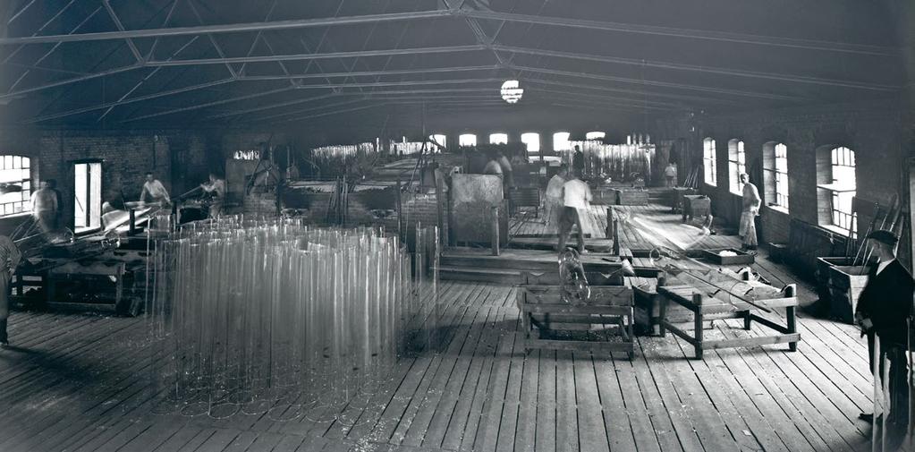 Fönsterglas tillverkades som höga smala cylindrar, vilka sedan slitsades upp och sträcktes ut. På hyttgolvet syns sådana cylindrar stående. 1.
