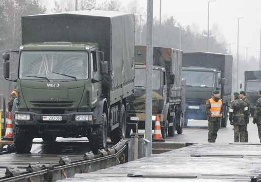 ZO SVETA, Z DOMOVA 15 EŠALÓN NATO SMERUJE DO LITVY Na snímke zo včerajška sú vozidlá Severoatlantickej aliancie naložené vojenským materiálom pri nakladaní na transportný vlak, ktorý ich z