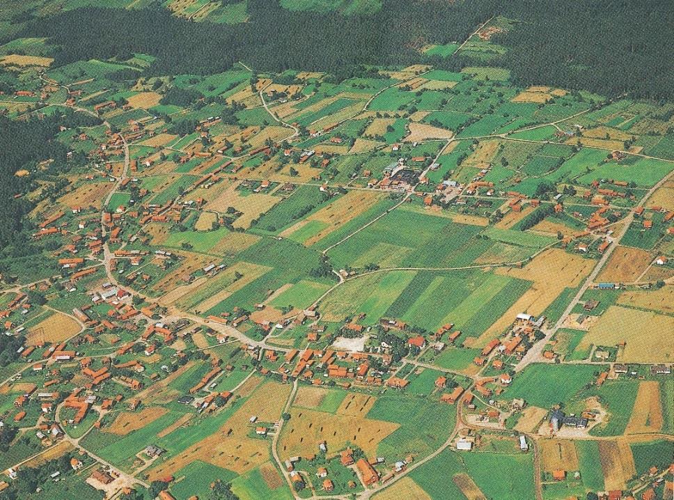 Bild över Nusnäs från omkring 1980 med den för Siljansbygden typiska omfattande bebyggelsen, realarvets blockformiga ägo- och brukningsstrukturer i övre delen och storskiftets och ägosplittringens