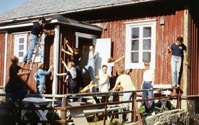 Ett glatt arbetslag sommaren 1982 har äntligen kunnat börja måla på husen. Fönsterarbeten är väldigt tidsödande.