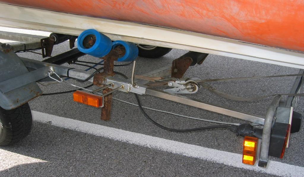 Fig 3. Säkerhetsvajern ska fästas som på bilden. Försök få båten att ligga bra på trailern. MOTOR Tvåtaktsolja (om det varnas i konsol på styrpulpeten) finns längst fram i båten.