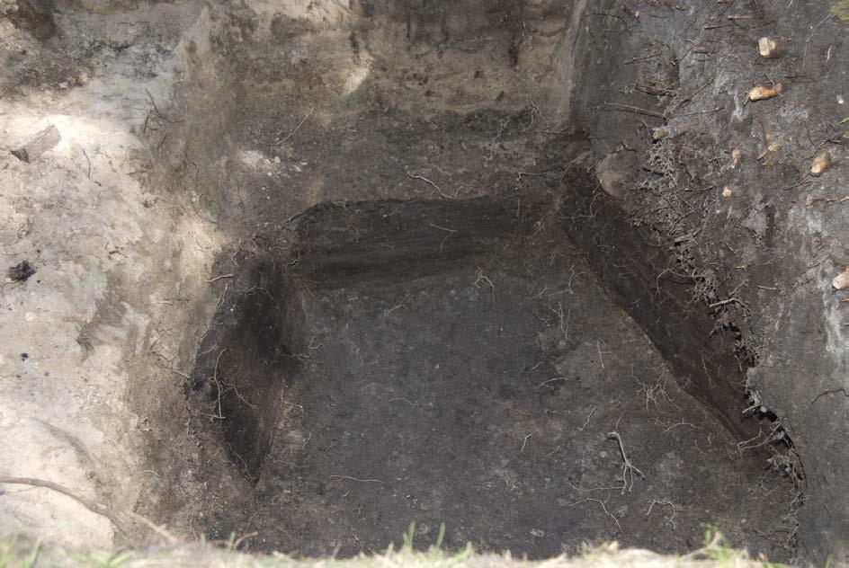 Fig. 11. Plankorna i brunnens botten. Foto taget från söder. Cirka 60 cm utanför den förmodade östra kortsidan på byggnaden återfanns rester av en stensatt brunn.