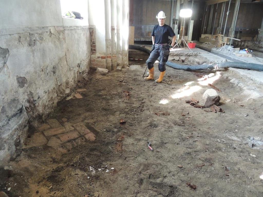 Tegelgolv 6 Vid schaktningsövervakningen av sugbilsarbetet för att ta bort uppstickande delar av bjälklag 2 och bärlager 3, framkom områden med fiskbensmönstrat tegelgolv 0,5 0,7 m under den sentida