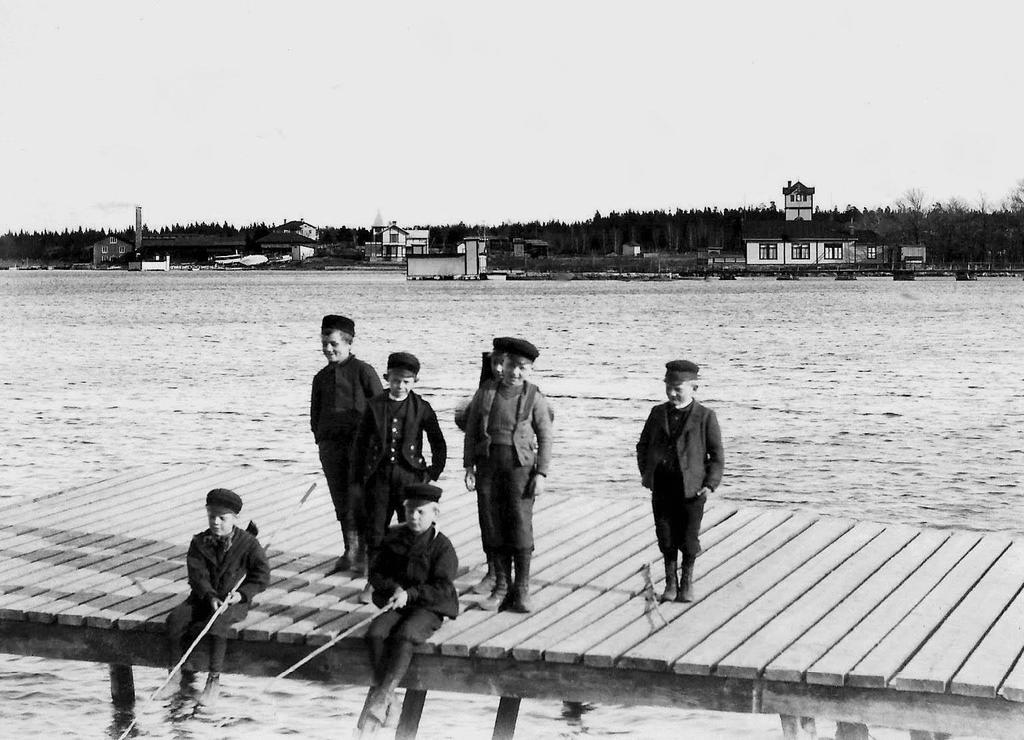 Metande pojkar på bryggan vid Klapphuset omkring 1900. Längst bort t v ses ångsågen och kvarnen, kallbadhuset mitt i bild.