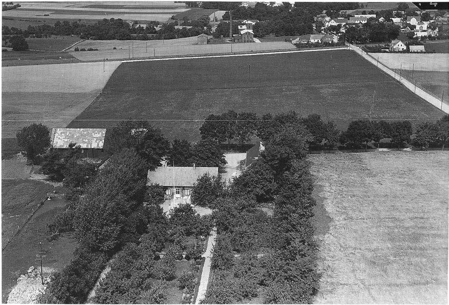 Fig. 6. Flygbild mot norr över sydvästra delen av Södra Sand by, med Almbackens gård i förgrunden och Fågelsångsdalens östligaste del i bakgrunden.