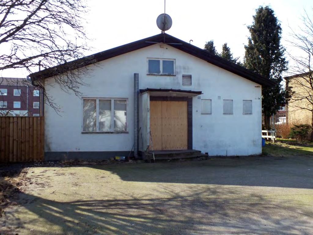 Gaveln till Hantverksföreningens hus, Flamingo med parkeringen i förgrunden. Entrén sattes igen i samband med att kommunen övertog ägandet i väntan på att riva byggnaden.