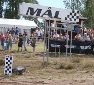 Mållinjen ska vara markerad med ett svart/vitt rutmönster, max höjd 50cm i bankant på vardera sida om banan. Inom målområdet skall också finnas följande: - Ett ställ med samtliga flaggor enligt SR MX.