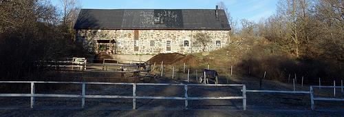 Bild 10. Stallbyggnad sedd nerifrån uteridbana och rastfållor. Bild 11.