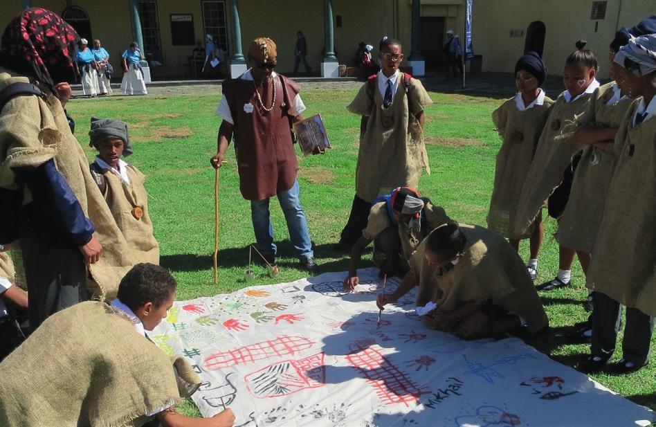 Symboler för ursprungsbefolkningen khoi målas vid en tidsresa för allmänheten till 1667 på Castle of Good Hope, Kapstaden, Sydafrika. Kan man ha två identiteter, både khoi/ färgad och vit europé?