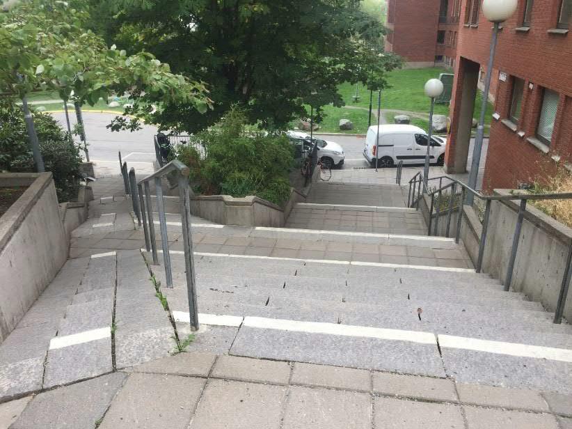 Kontrast-/varningsmarkering på nivåskillnad (trappa utvändigt) Typ av byggnad/plats: Utvändig trappa med flera vilplan och barnvagns ramp i natur- och betongsten i parkmiljö.