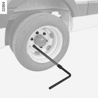 HJULBYTE: hydraulisk domkraft (1/3) Lossa hjulets fästskruvar genom att placera hjulnyckeln 3 med det sexkantiga förlängningsskaftet 2 (som finns i verktygssatsen) så att den trycker ovanpå.