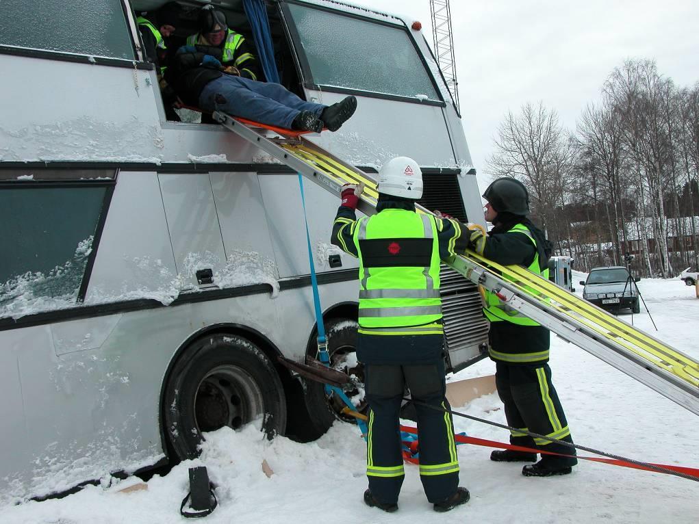 Förankring av stegen mot bussen och underlaget sker genom att använda spännband (pilarna) som kan placeras enligt Figur 10.8.