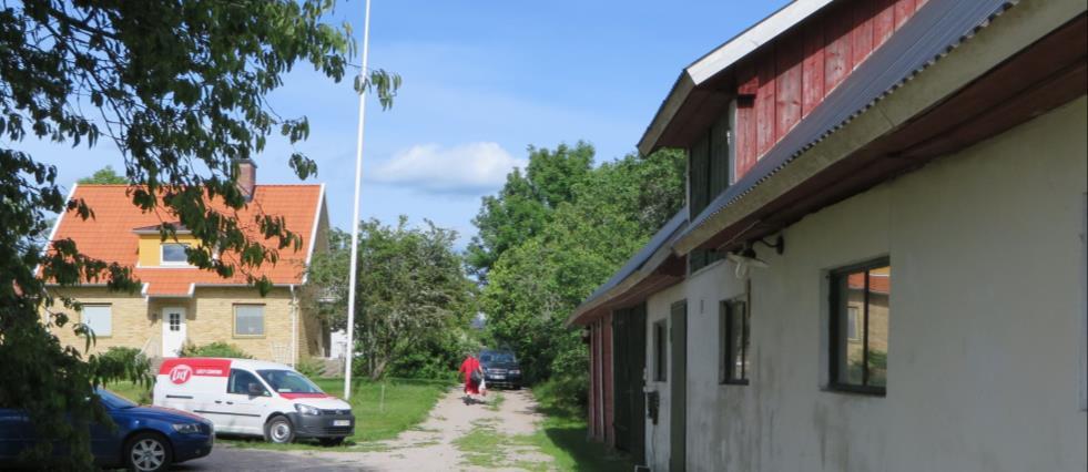 Landsvägen går mellan bostadshus och ladugård.