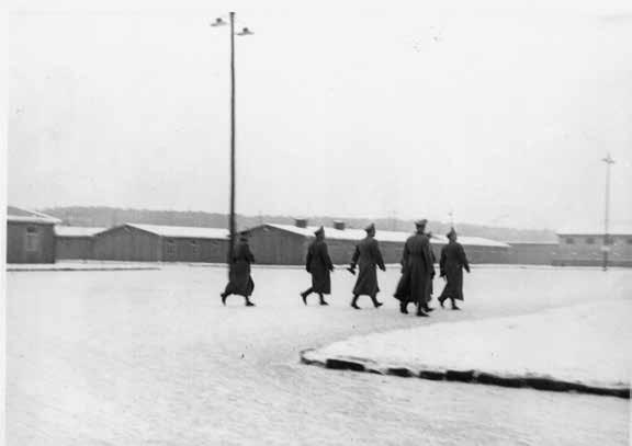 16 Besuch des Reichsführers der SS und Chef der Deutschen Polizei Heinrich Himmler, und Gefolge auf dem Weg zum Barackenlager über dem sog. Appellplatz, 1940/41.