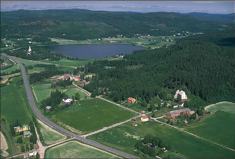 Fig. 7. Styrnäs kyrka från sydväst. Kyrkan ligger på en udde i Ångermanälven, mitt i det smala odlingslandskapet som följer älvens lopp.