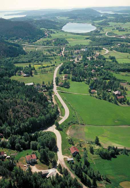 Fig. 9. Vy över dalgången vid Arnäs kyrka med Örfjärden i fonden. Till kyrkomiljön hör prästgård, skola, sockenstuga, tiondebod och kyrkstallar.