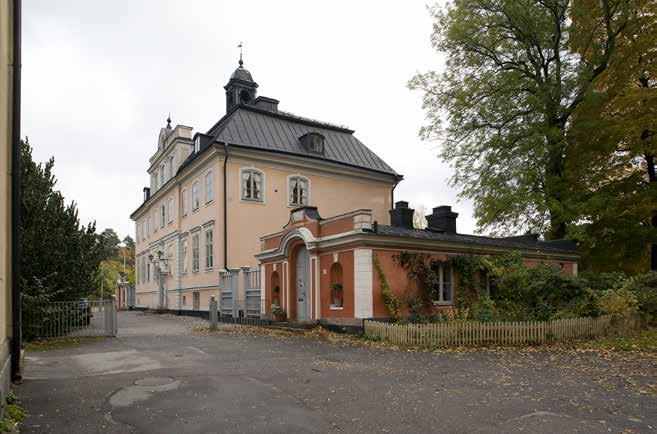 HUVUDBYGGNADEN MED DEN VÄSTRA PAVILJONGEN. MELLAN PAVILJONGERNA OCH HUVUDBYGGNADENS GAVLAR ÄR HÖGA TRÄSTAKET, UTFÖRDA EFTER ORIGINAL FRÅN 1800-TALETS MITT. FOTO I. JOHANSSON, SSM. båthus.