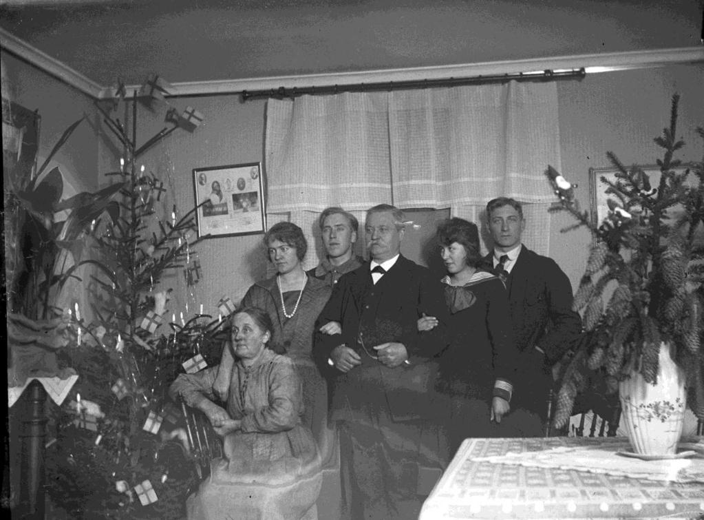 Carl Petters hustru hette Anna. Deras tre barn var Folke, Benny och Märta. Byggnaden där Lundstens affär fanns (70). Sin vana trogen ställer Joel familjen framför huset.