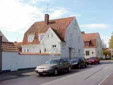 Utbyggt trapphus med sadeltak mot öster. Burspråk i två våningar mot söder, med valmat tegeltak.