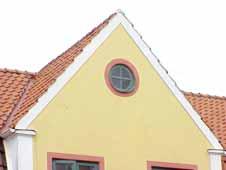Röda dörr- och fönsteromfattningar. Kraftig vit profilerad gesims. Vita knutar.