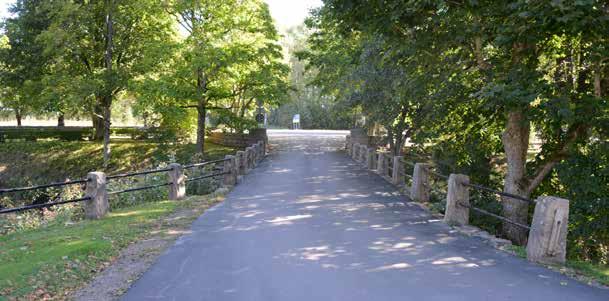 Bron begränsas av en stenmur på den norra sidan medan utfarten från kyrkogårdsområdet är mer