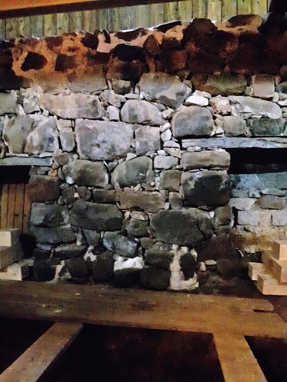 Vattenmöllan kvarnmurens renovering Till vänster kvarnens södra mur och i förgrunden del av kvarnstolen. Där är muren kallmurad.