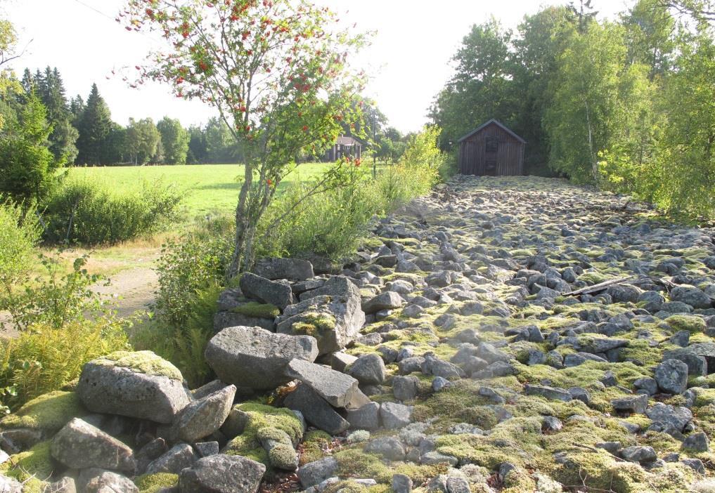 Den ca 10 meter breda stenmuren, med gården och ett