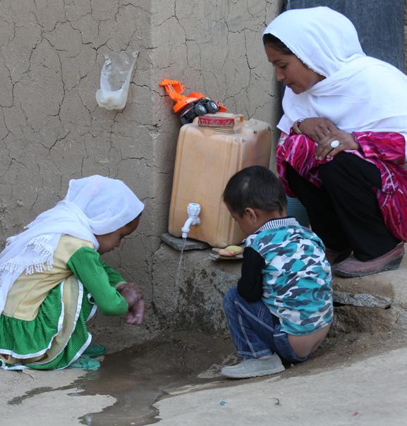 UNICEF/Fricker Hundratals samhällen i Afghanistan är nu Open defecation-free Mercia kontrollerar att hennes barn tvättar händerna ordentligt utanför sitt hem i Nili-distriktet, i centrala Afghanistan.