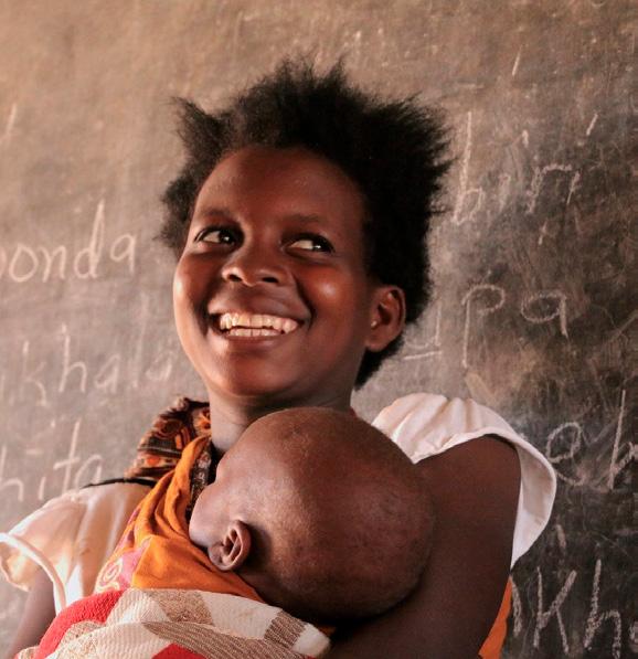 Skolan har förändrat Aminas liv Amina James, 19, håller upp sin bebis framför svarta tavlan i byn Nsomba, i sydöstra Malawi.