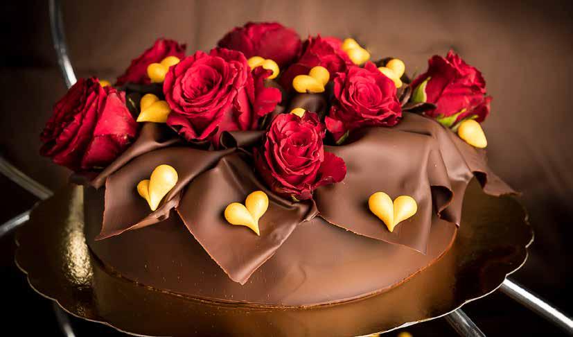 Chocolate Lover Sveps in i spröda vita eller mörka chokladjok. Ni väljer själva mellan våra franska moussesmaker. Dekorationen består av handmodellerade marsipanhjärtan och färska rosor.