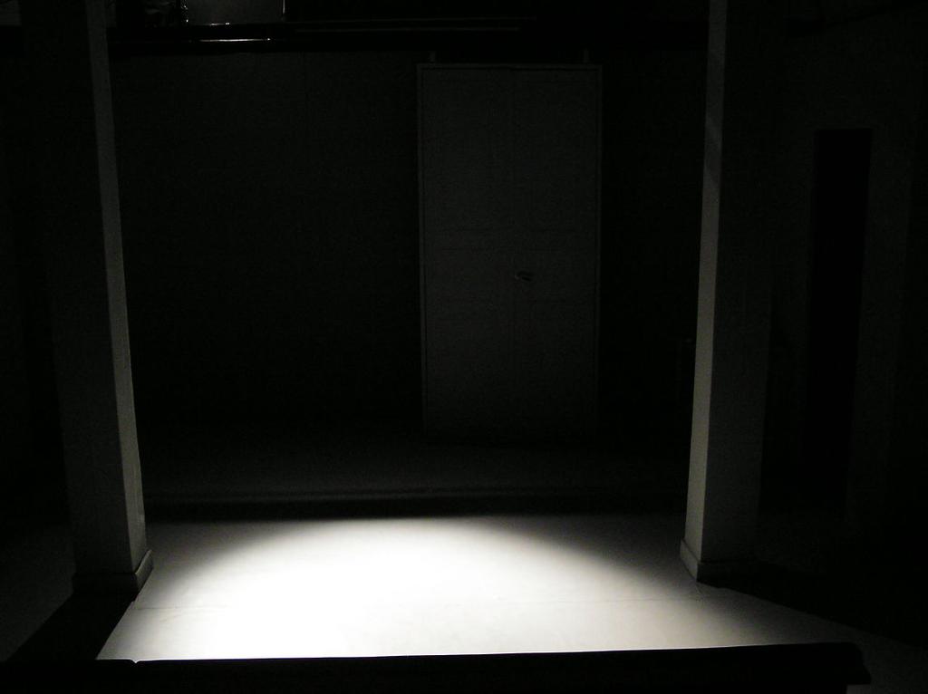En skådespelare stående vid väggen ska ha ljus i ansiktet.