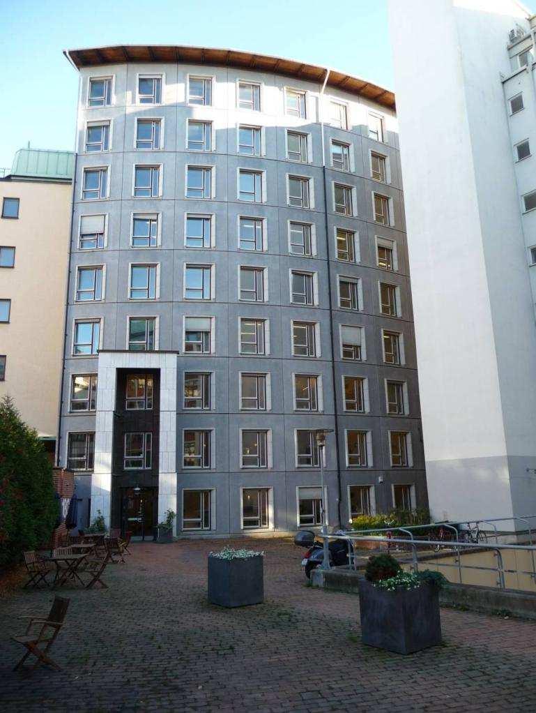 SID 31 (54) I början av 1990-talet tillkom det böjda gårdshuset, ritat av Alenius Silfverhielm Åhlund arkitektkontor. Fasaden utfördes med betongelement med raffinerat snedställda fönsteromfattningar.